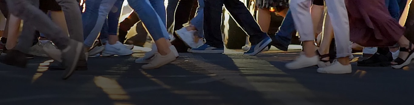 Mestni prehod, ki prikazuje na desetine ljudi, ki hodijo v nasprotnih smereh, ko prečkajo cesto