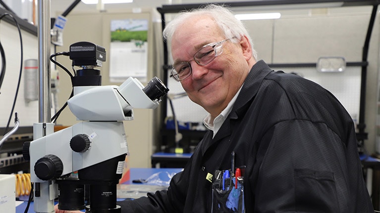 Dr. William F. Cooper sedi pri mikroskopu