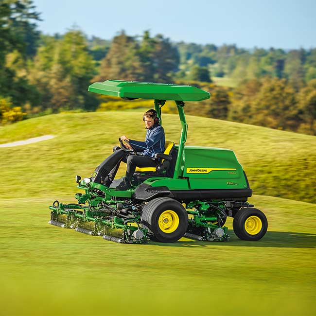 Vzdrževalec zelenic dela na travnatem območju s kosilnico za čistine John Deere