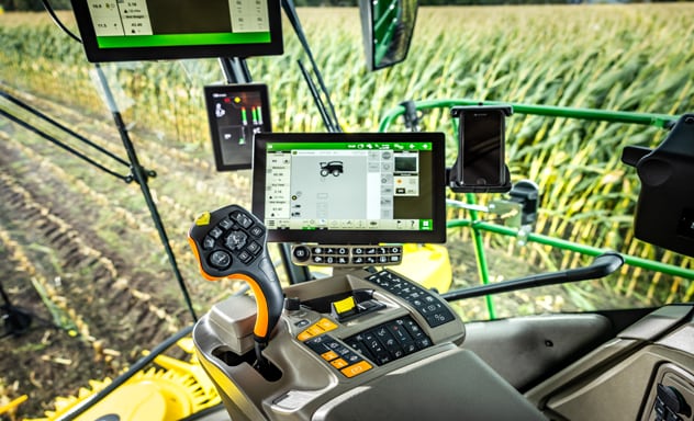 Samovozni silažni kombajn F9 700 pri nakladanju prikolice Joskin, ki jo vleče traktor John Deere 6R